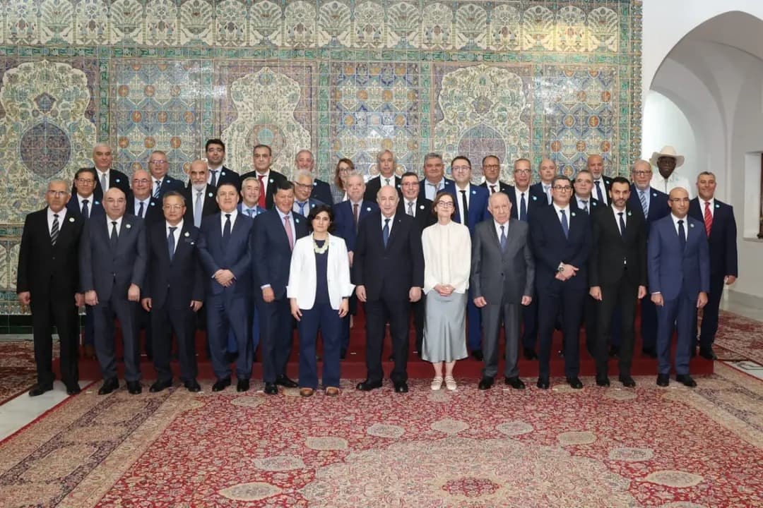 Photo de groupe des membres du Haut Conseil de la communauté scientifique nationale à l'étranger, devant un mur de faïences ornementales